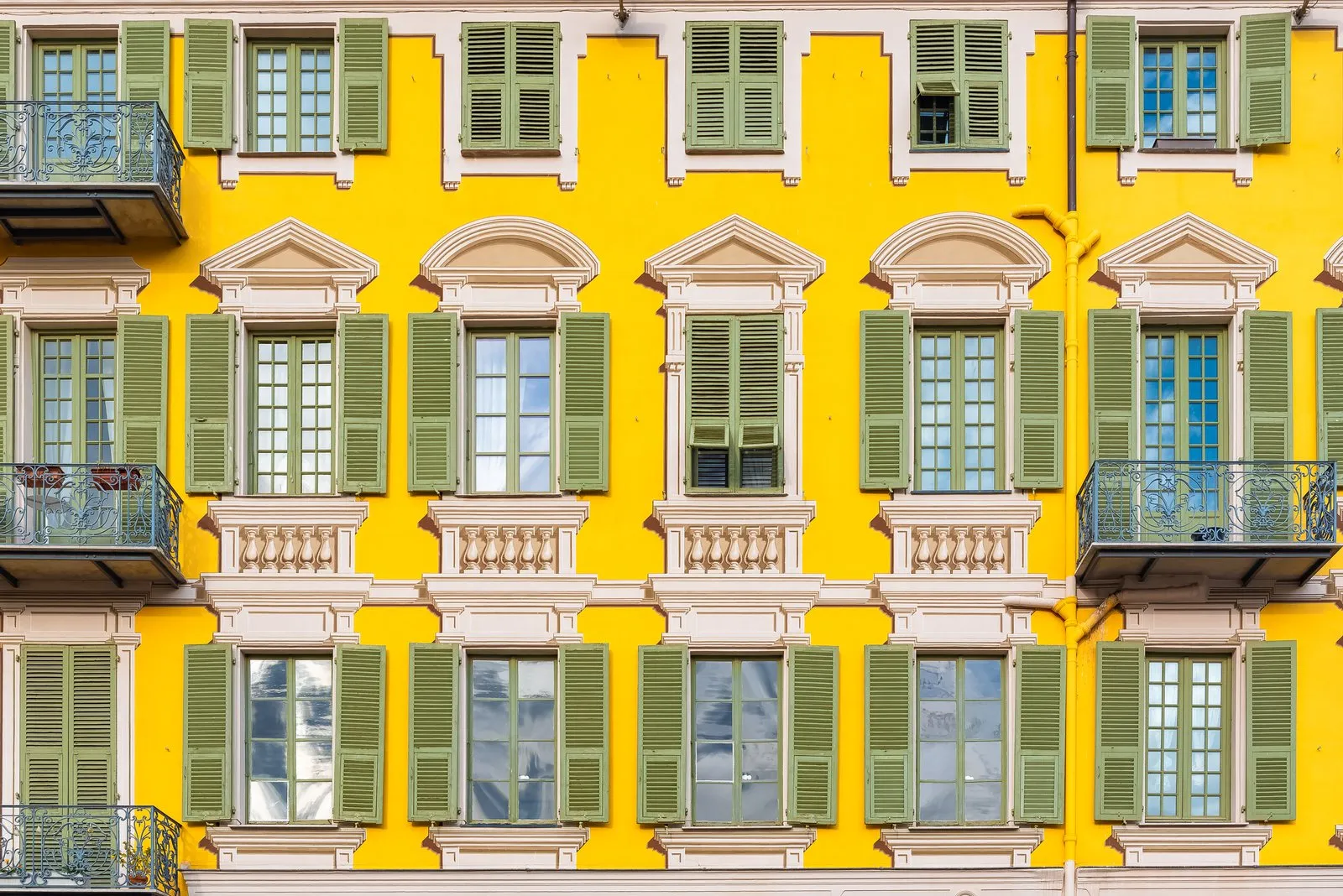 Une façade jaune et ses volets turquoise vue en hauteur, à Nice