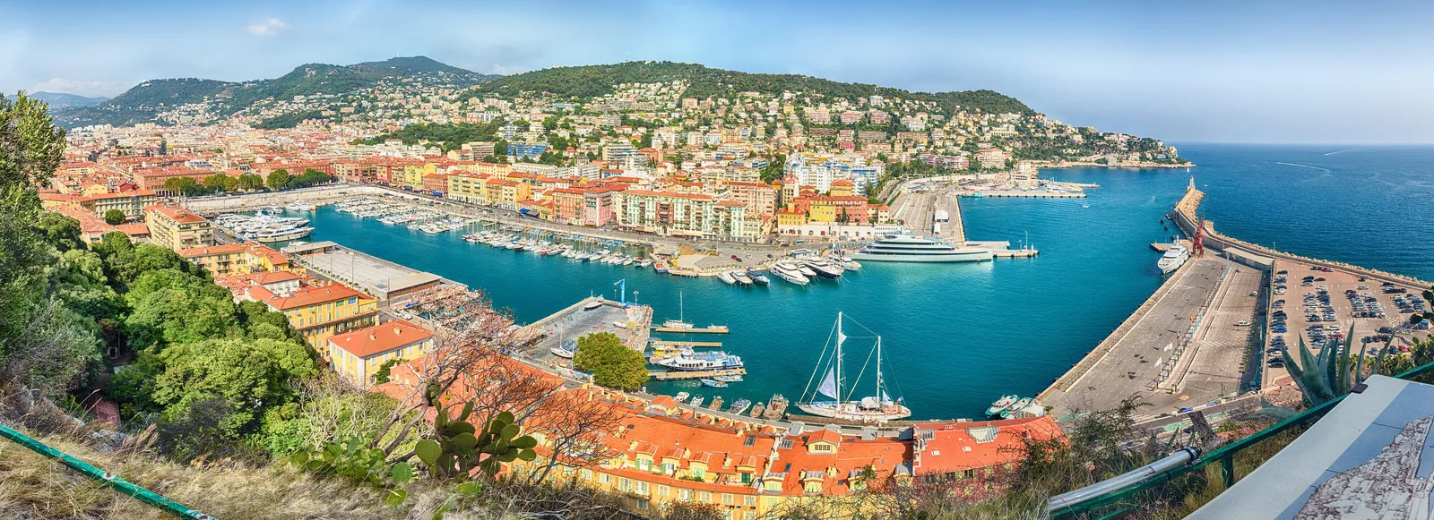 O porto e os seus barcos vistos do alto, a colina ao fundo