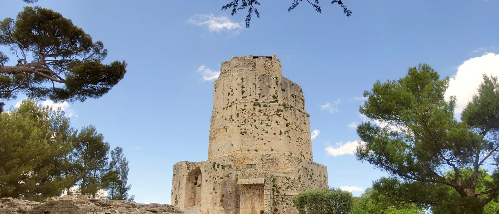 La tour Magne, tour romaine du mont Cavalier à Nîmes, entre les pins sous le ciel bleu