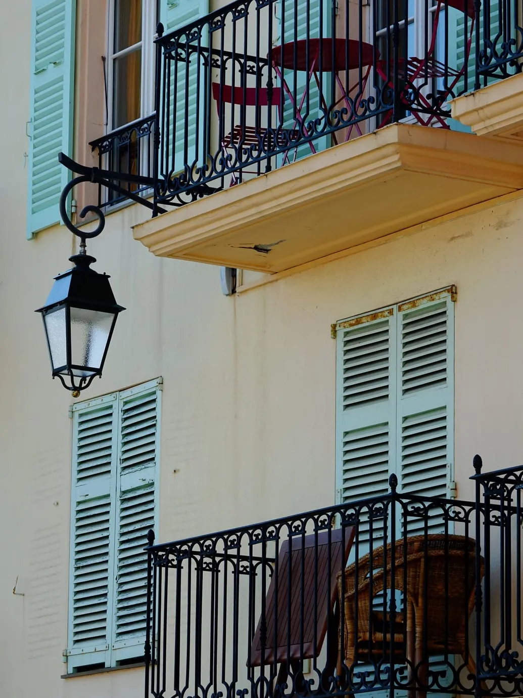 Une façade aux volets verts et sa lanterne