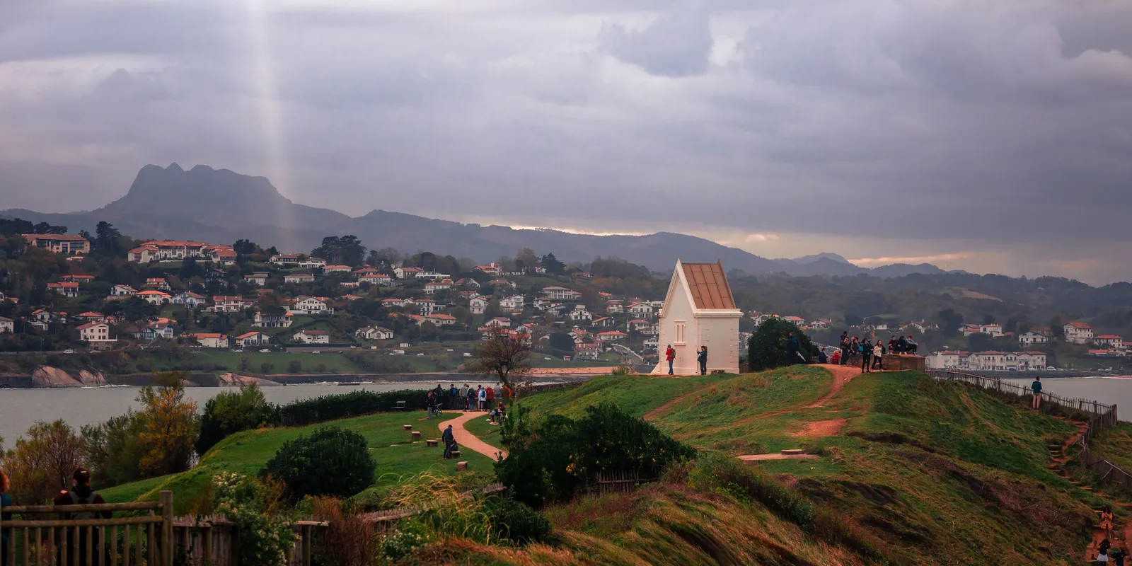 The Sainte-Barbe point in Saint-Jean-de-Luz, its white chapel above the bay, Ciboure and La Rhune under a stormy sky