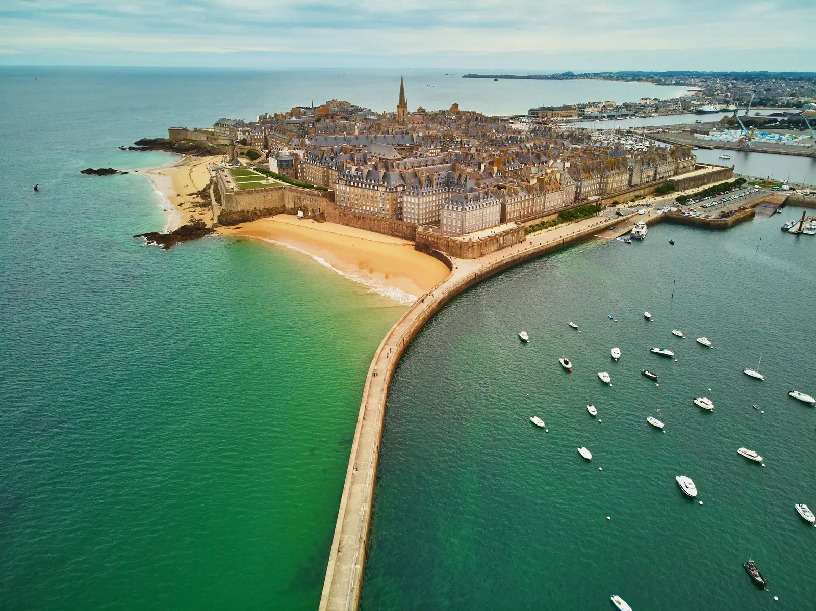 Saint-Malo intra-muros vista do céu, as suas muralhas, a praia e o molhe do porto com os veleiros
