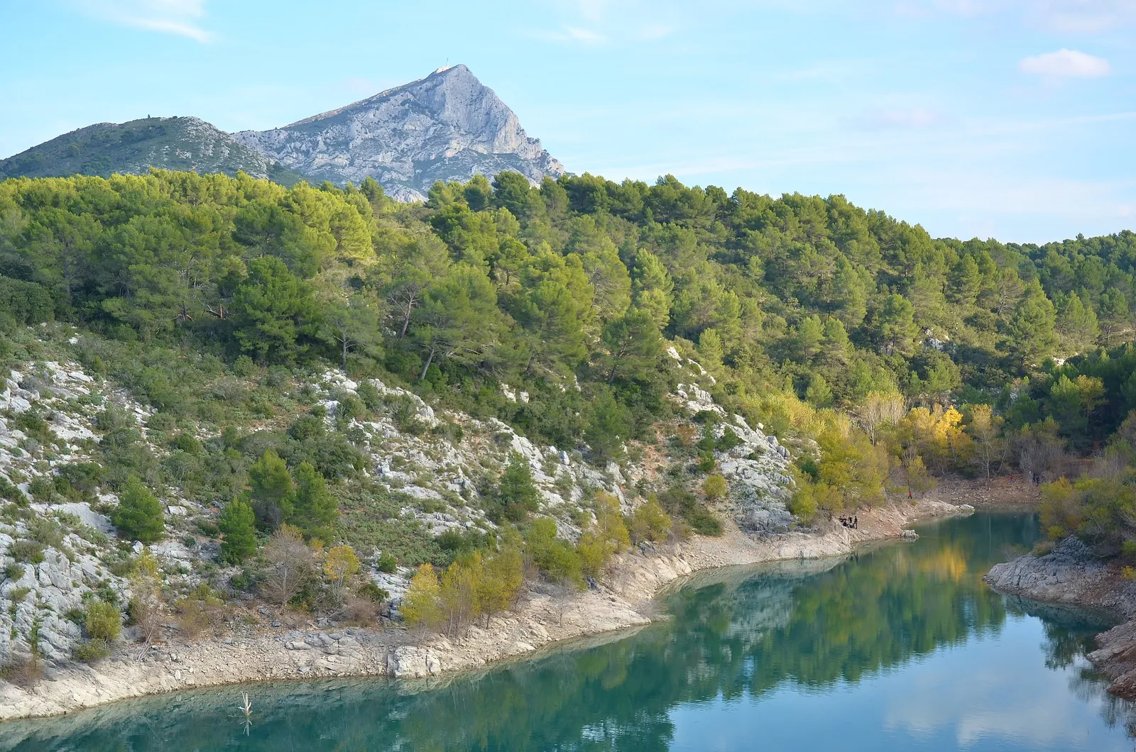 O lago de Bimont em Saint-Marc-Jaumegarde, as suas margens de calcário e pinheiros, a montanha Sainte-Victoire ao fundo
