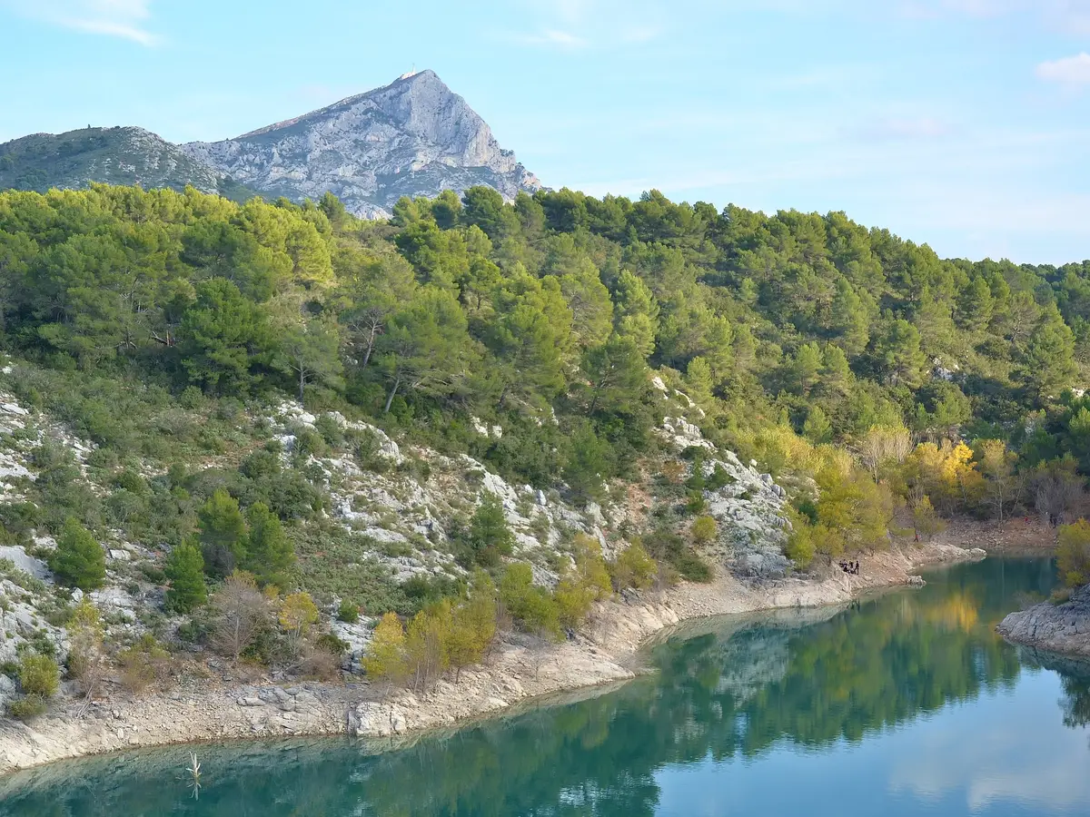 O lago de Bimont em Saint-Marc-Jaumegarde, as suas margens de calcário e pinheiros, a montanha Sainte-Victoire ao fundo