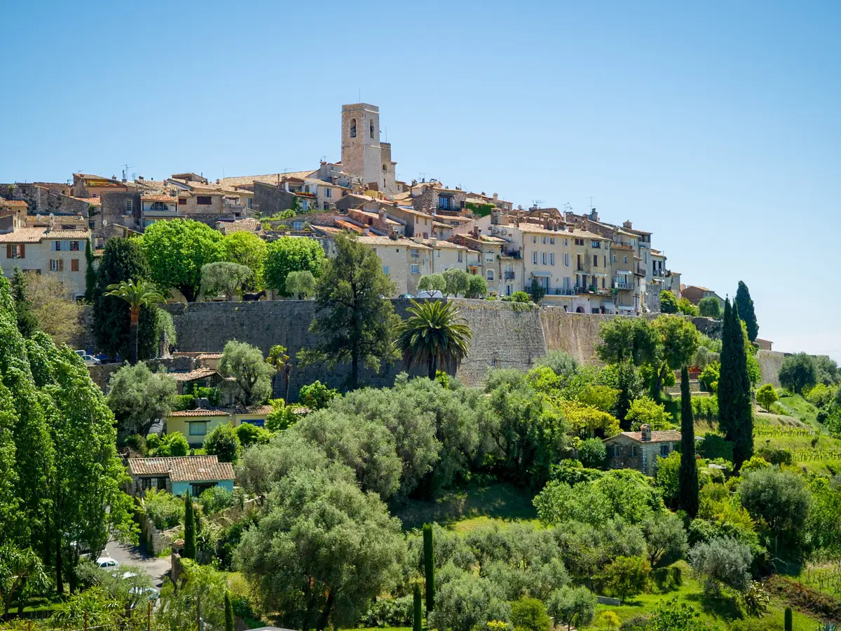 Saint-Paul-de-Vence sur sa colline : les remparts, le clocher et le village au-dessus des oliviers et des cyprès