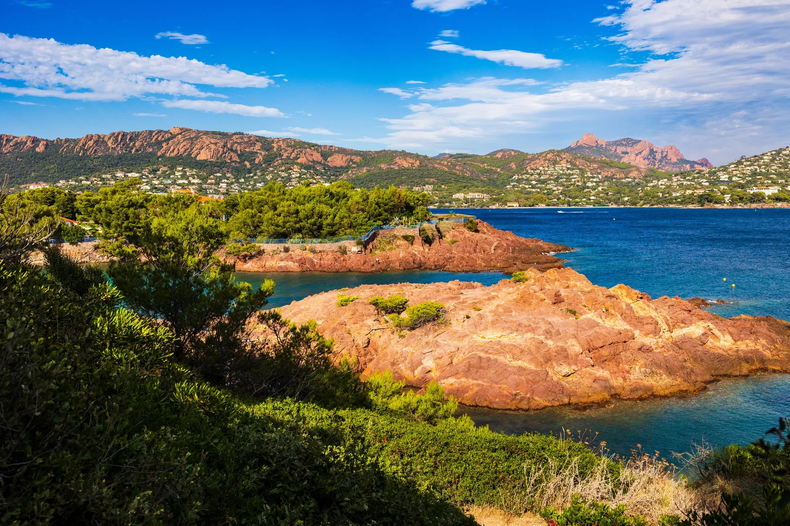 Os rochedos vermelhos da beira-mar, as villas na encosta e os picos do Cap Roux, entre Agay e Anthéor