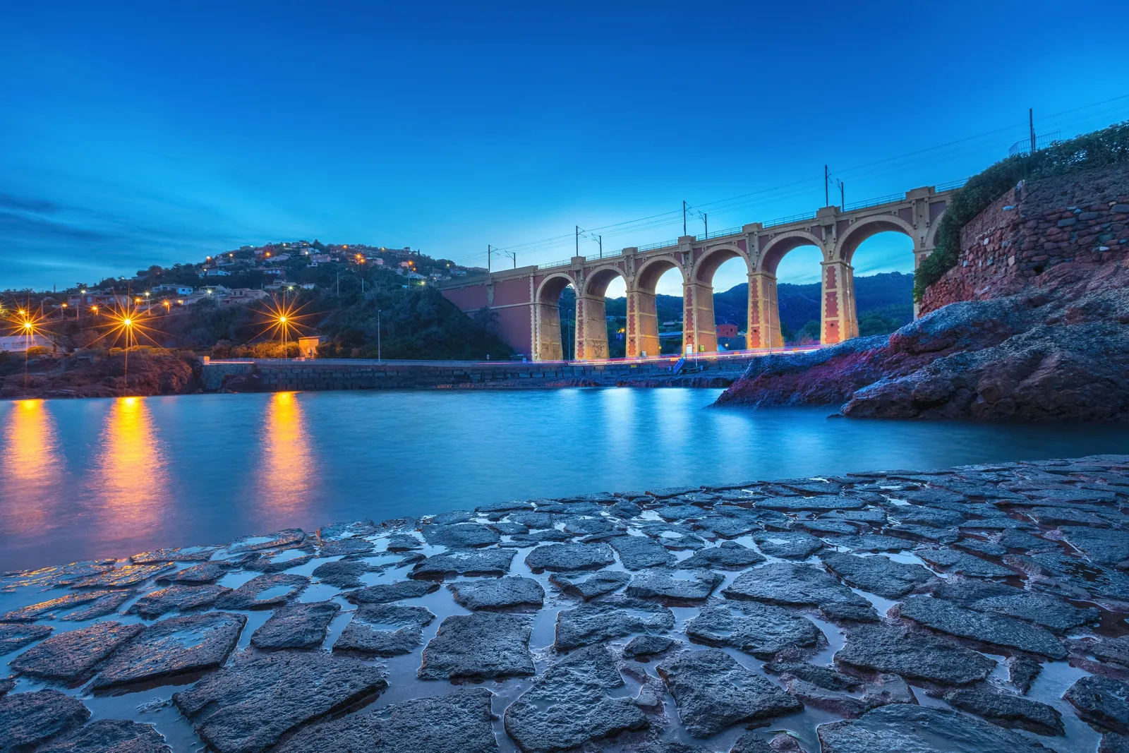 Le viaduc ferroviaire d’Anthéor à l’heure bleue, les roches rouges au premier plan