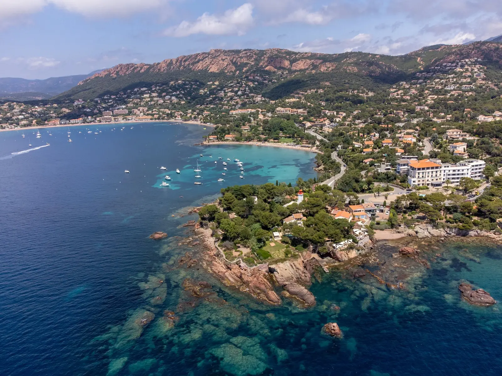 Villas entre os pinheiros em torno da enseada de Agay, o farol e a praia, ao pé do Estérel