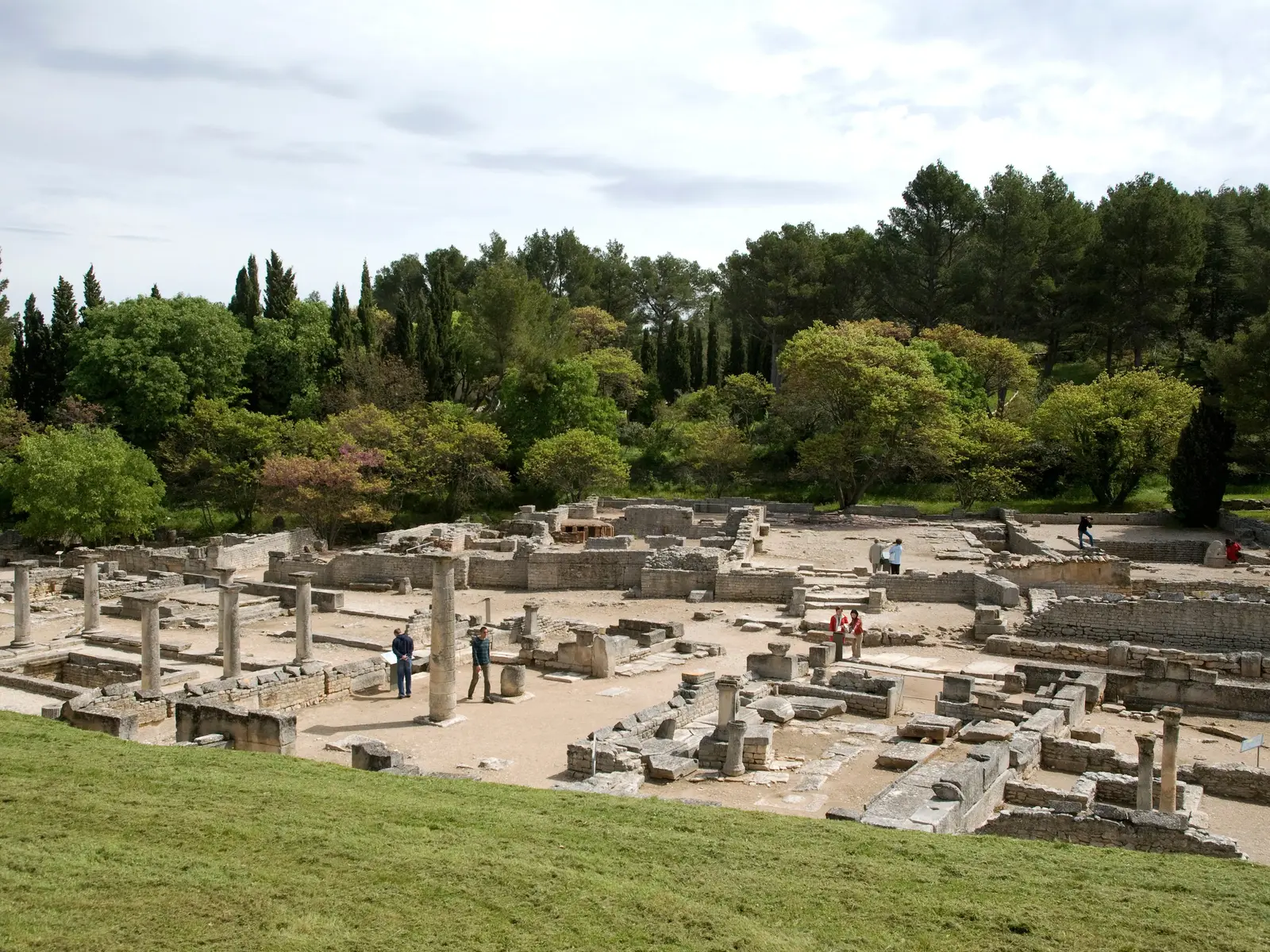O sítio antigo de Glanum em Saint-Rémy-de-Provence, as suas colunas e fundações romanas ao pé dos pinheiros e ciprestes