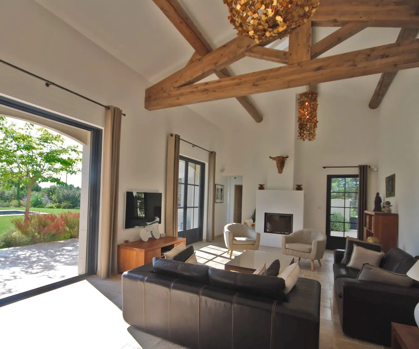 A living room with exposed beams opening onto the garden