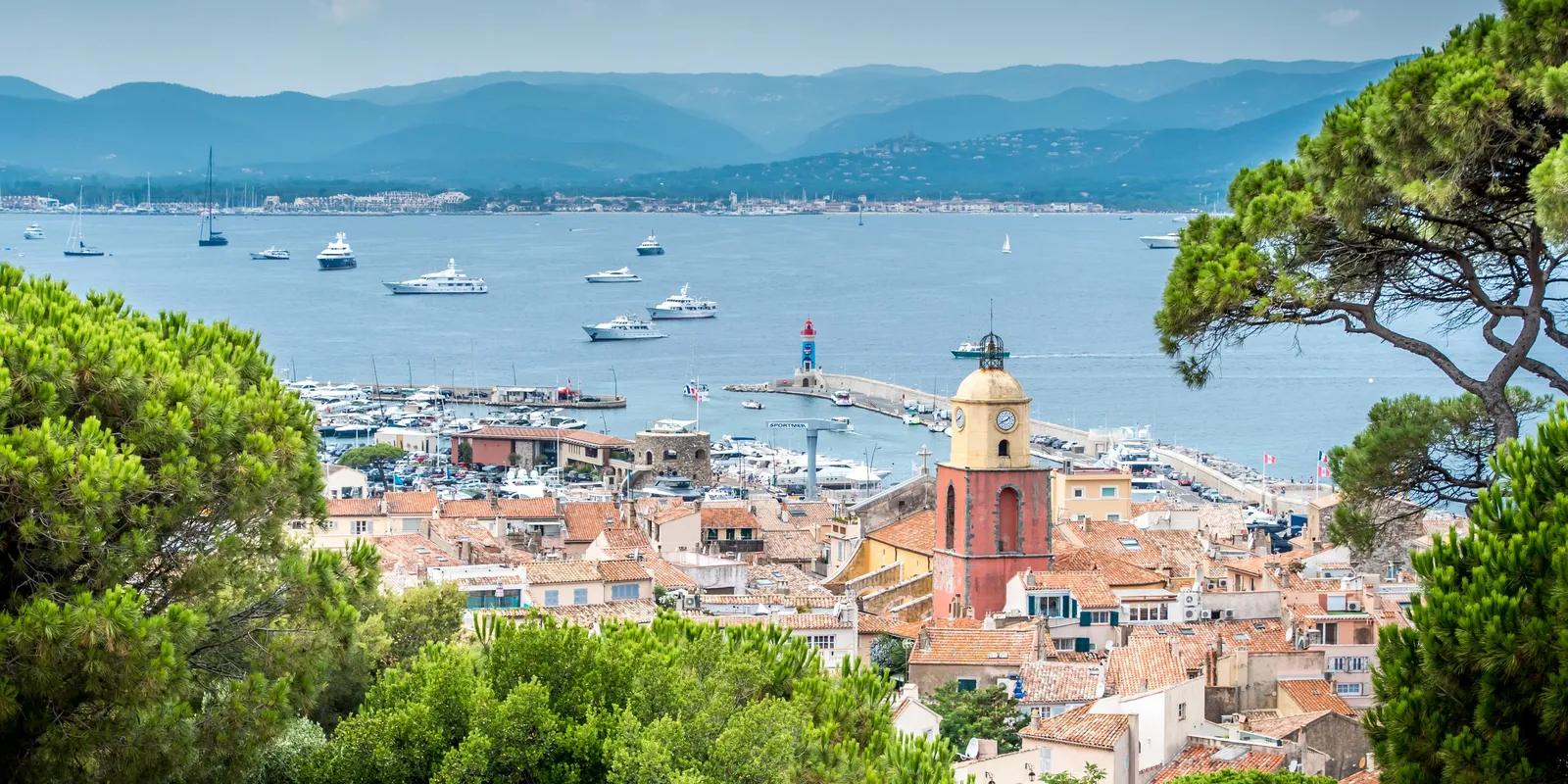The village, its bell tower and the harbour seen from the heights, the gulf behind