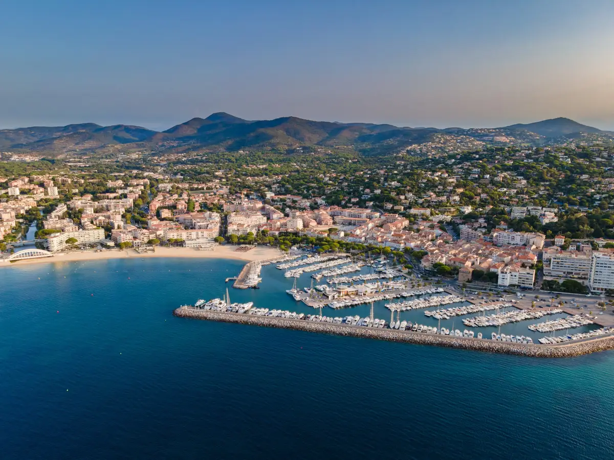 Sainte-Maxime vue du ciel : le port de plaisance, la plage et la ville au pied des collines des Maures