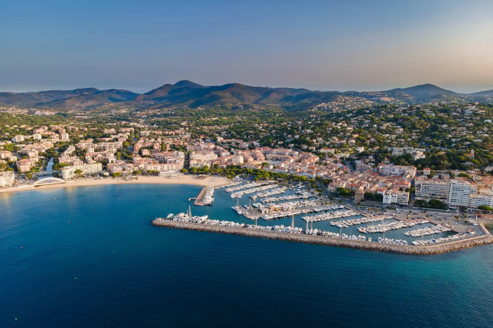 Sainte-Maxime from the air: the marina, the beach and the town at the foot of the Maures hills