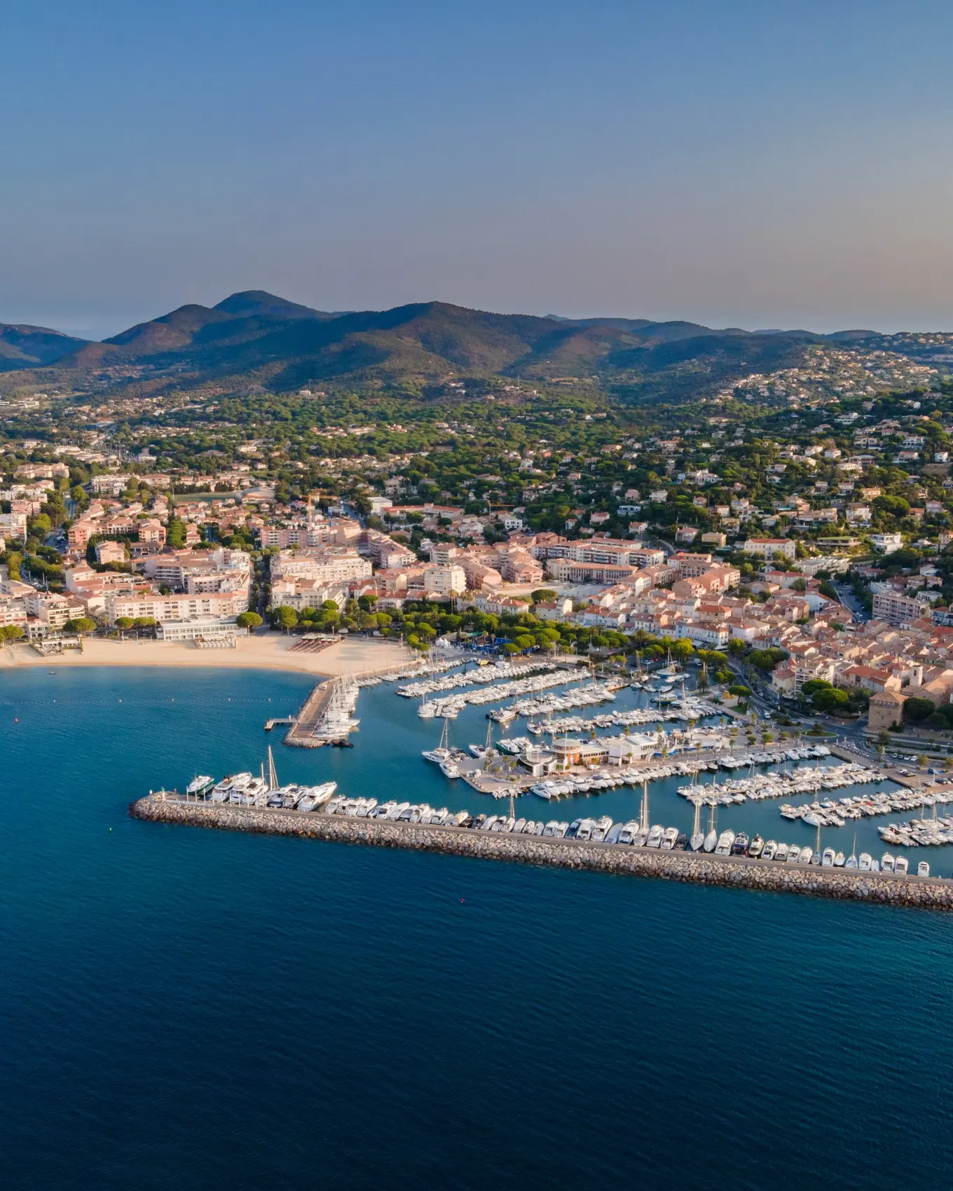 Sainte-Maxime from the air: the marina, the beach and the town at the foot of the Maures hills