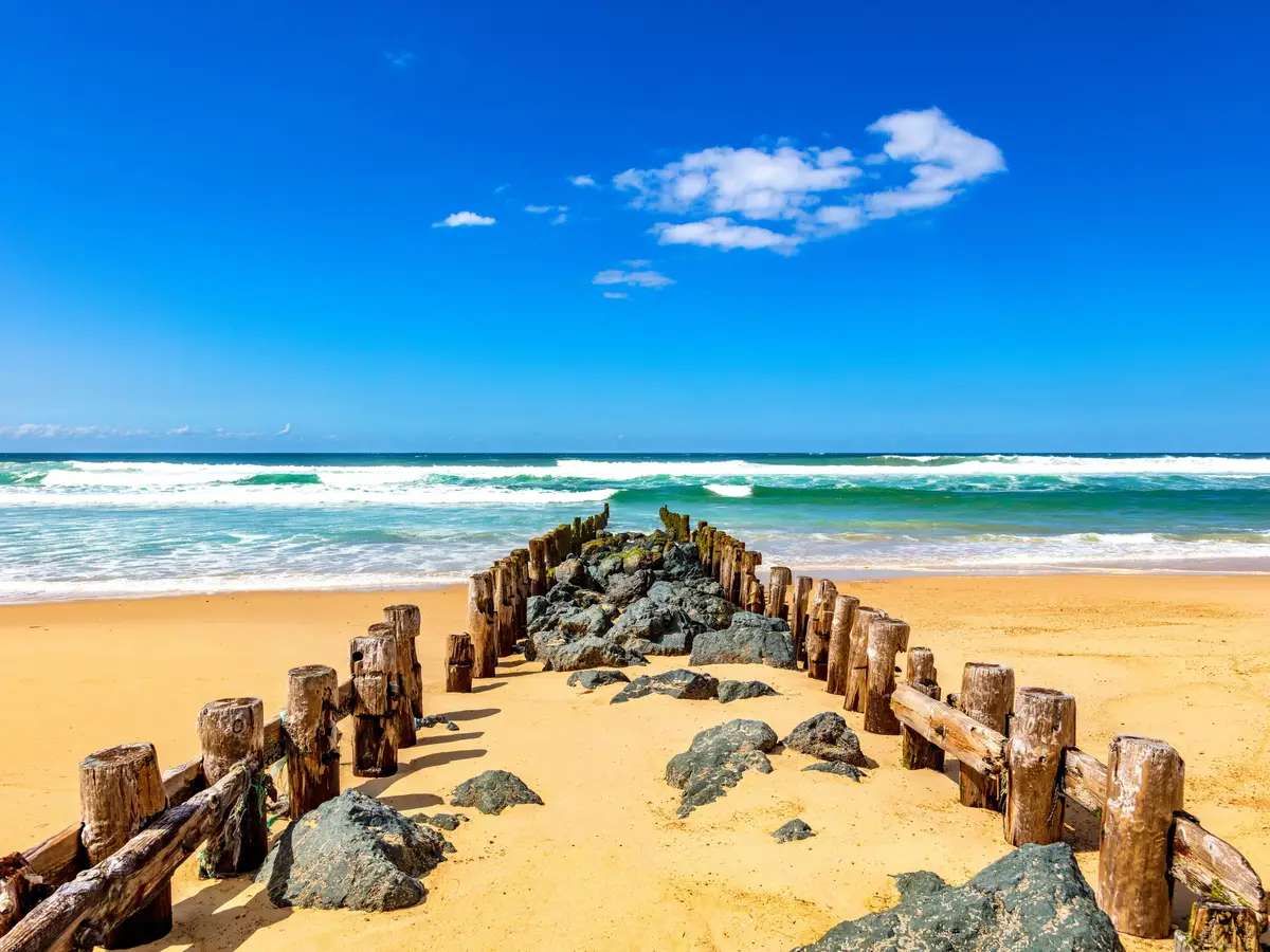 Um esporão de estacas de madeira e rochas na praia de Seignosse, de frente para o oceano