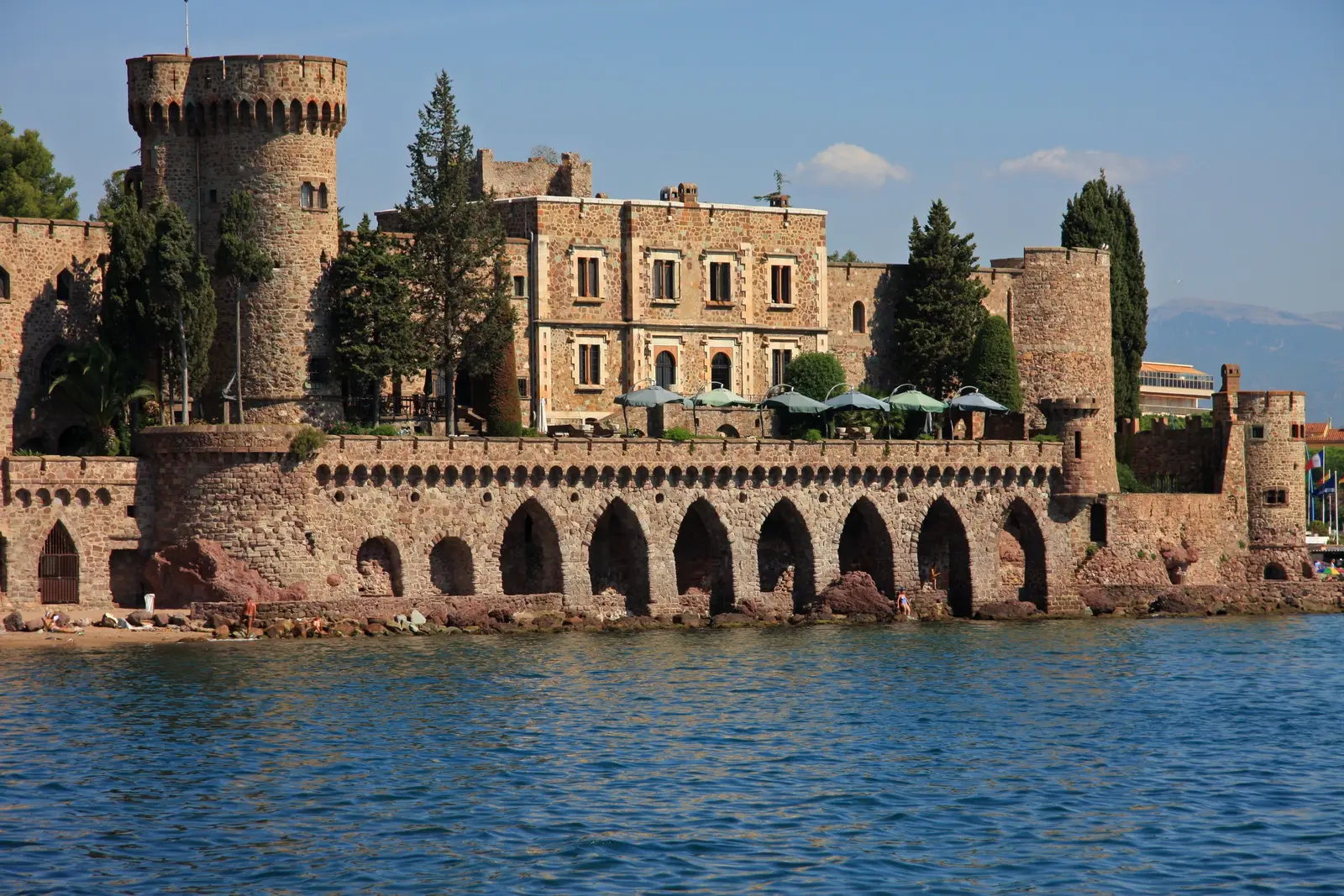 O castelo de Théoule-sur-Mer e as suas arcadas à beira da água, as suas torres ameadas sob os pinheiros
