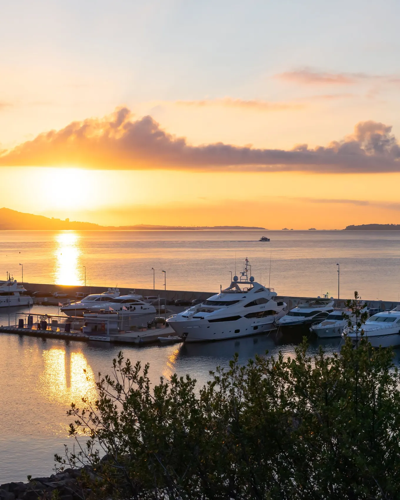 Le port de Théoule-sur-Mer au lever du soleil, ses yachts à quai et le golfe à l’horizon