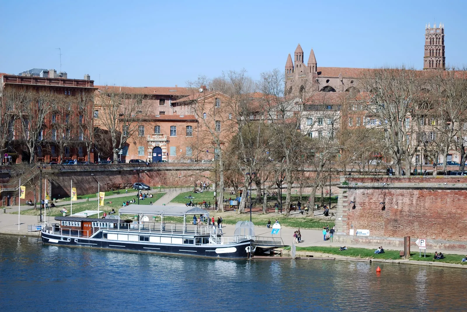 A pleasure boat moored on the Garonne in front of the brick quays