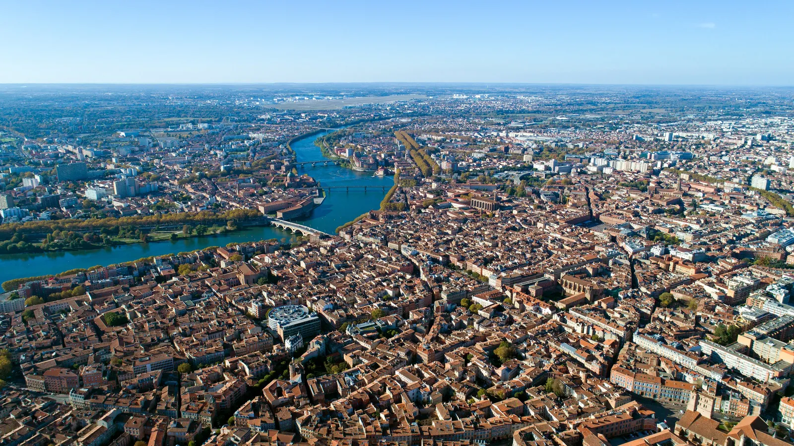 The centre of Toulouse seen from the sky, its brick roofs and the Garonne to the horizon