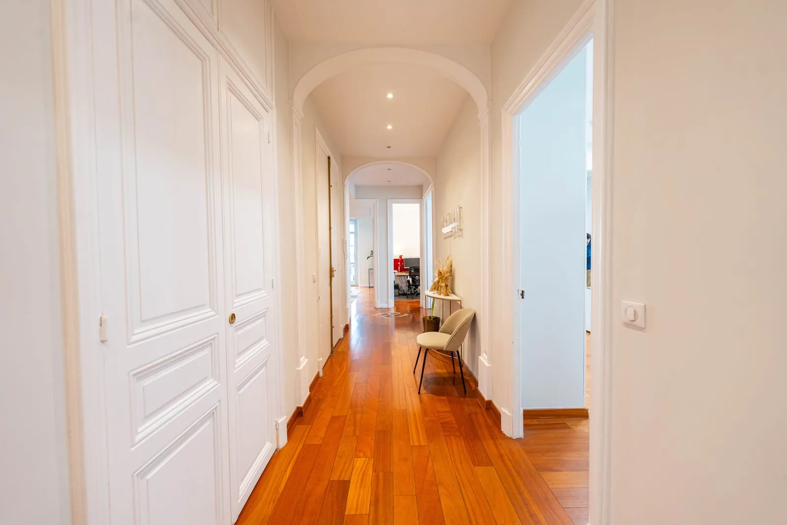 An apartment hallway with wooden parquet flooring