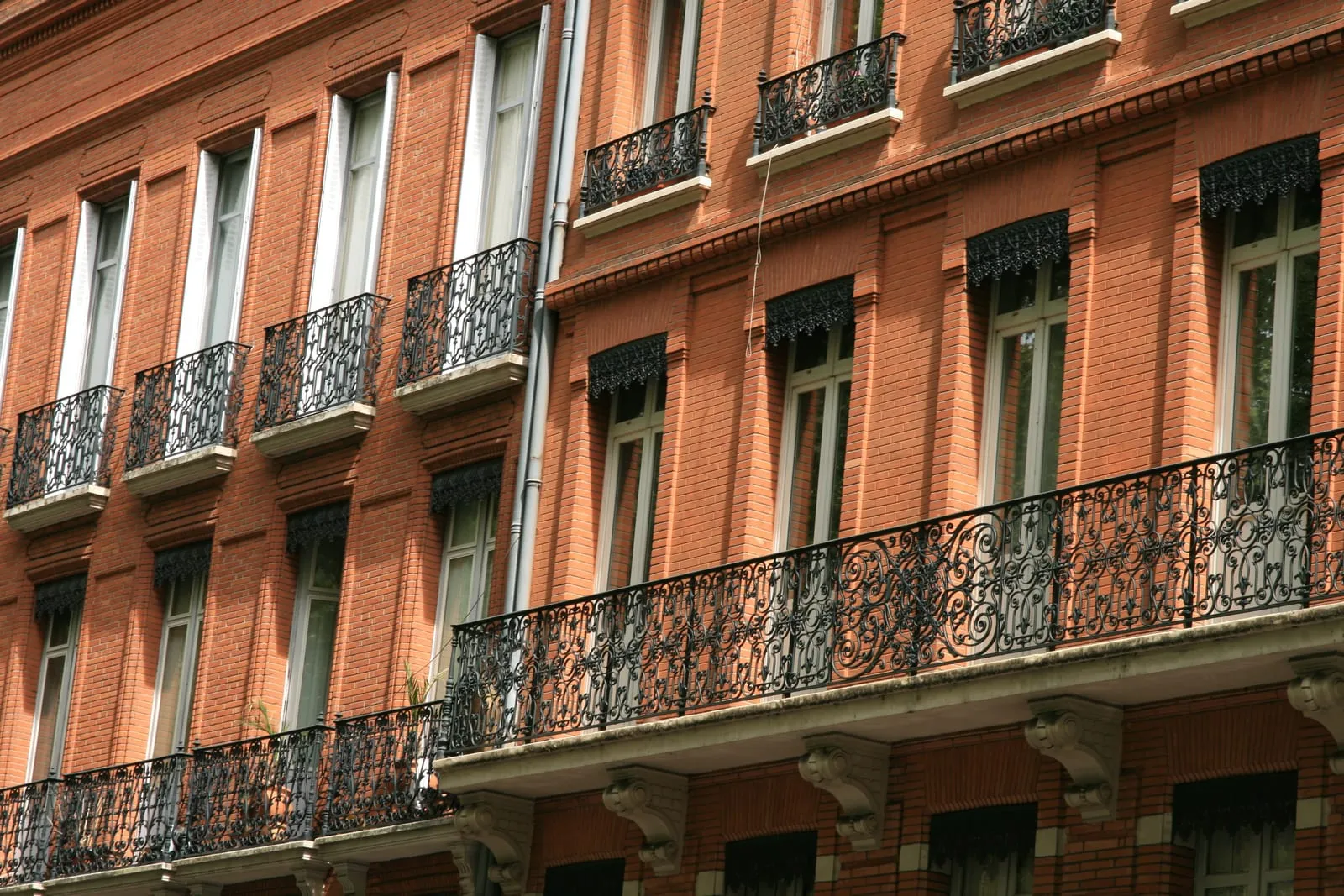 A brick façade with wrought-iron balconies