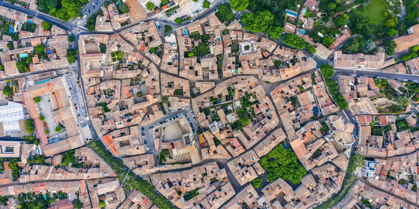 Le cœur historique d’Uzès vu à la verticale, ses toits serrés dans l’anneau des boulevards plantés