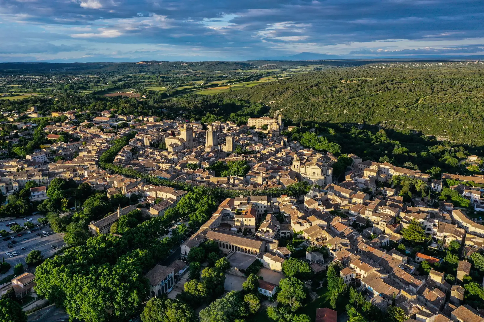 Uzès vista do céu, os seus telhados de telha, as torres e a catedral acima da garrigue