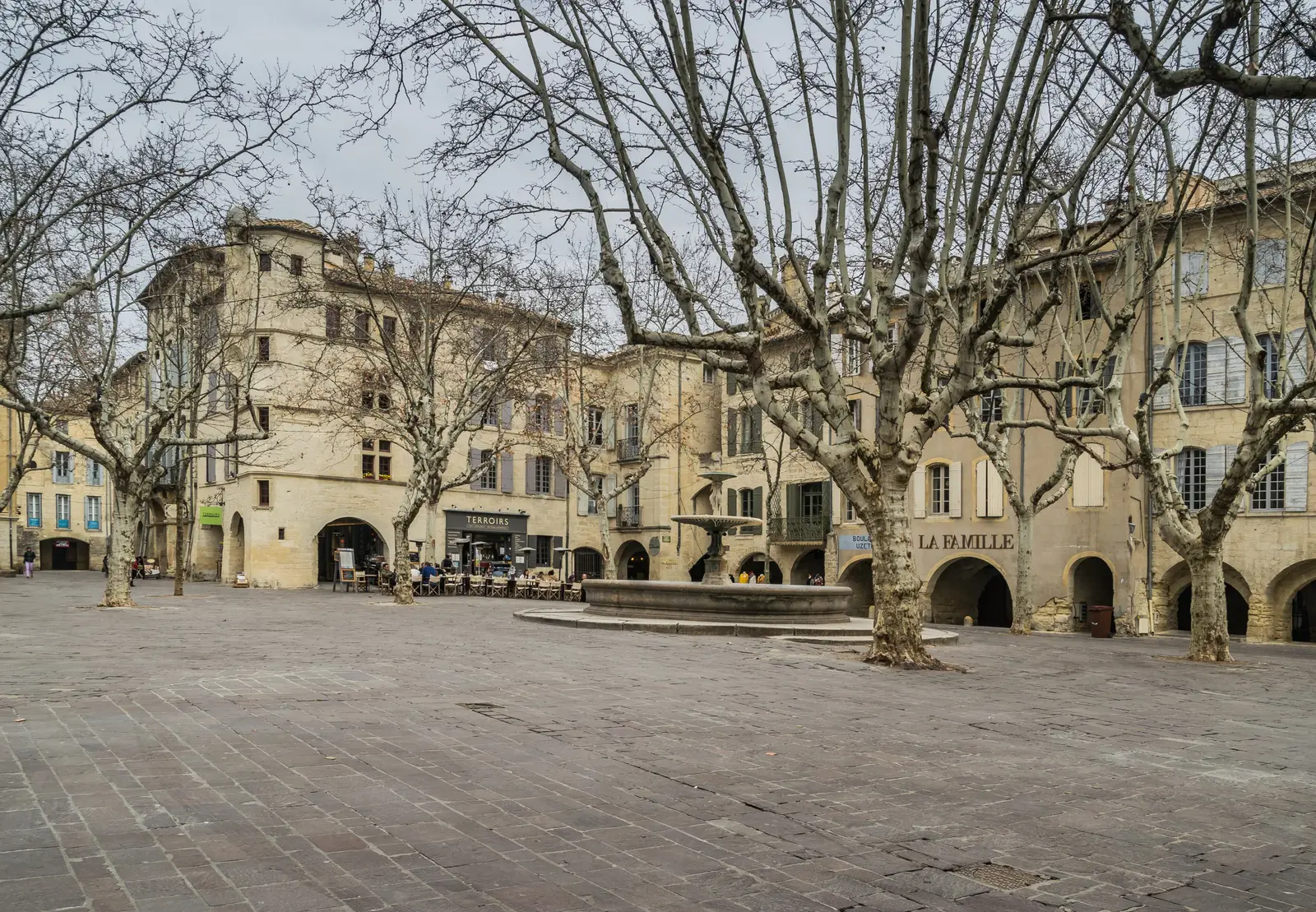 A place aux Herbes de Uzès, as suas arcadas e plátanos