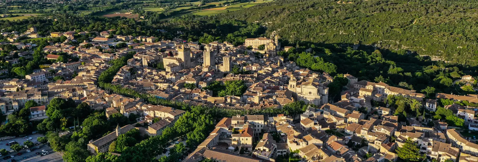 Uzès vu du ciel, ses tours médiévales au milieu des toits et la garrigue jusqu’à l’horizon