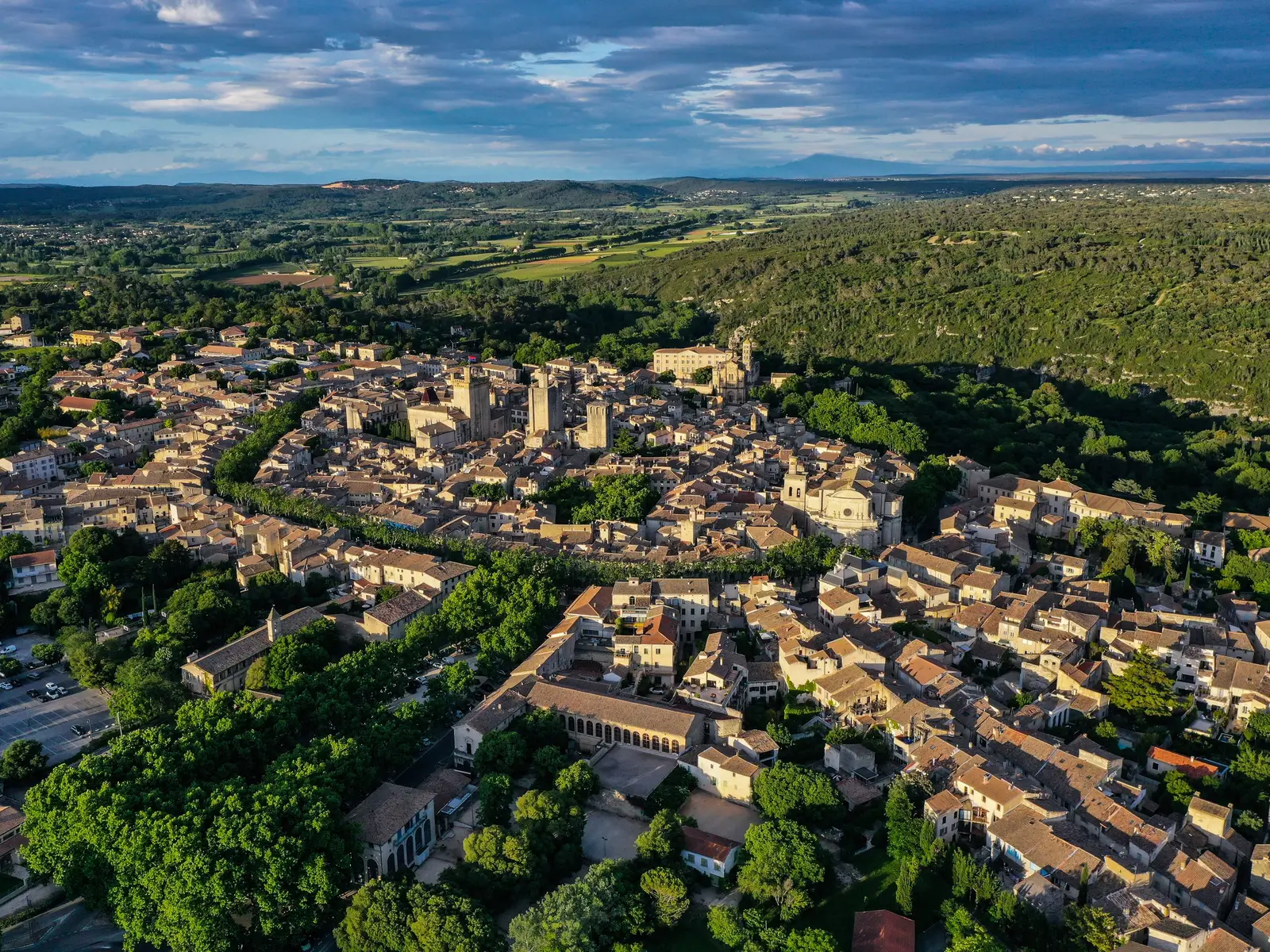 Uzès vista do céu, as torres medievais entre os telhados e a garrigue até ao horizonte