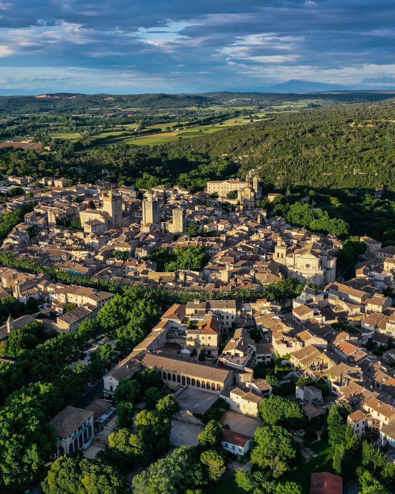 Uzès vu du ciel, ses tours médiévales au milieu des toits et la garrigue jusqu’à l’horizon