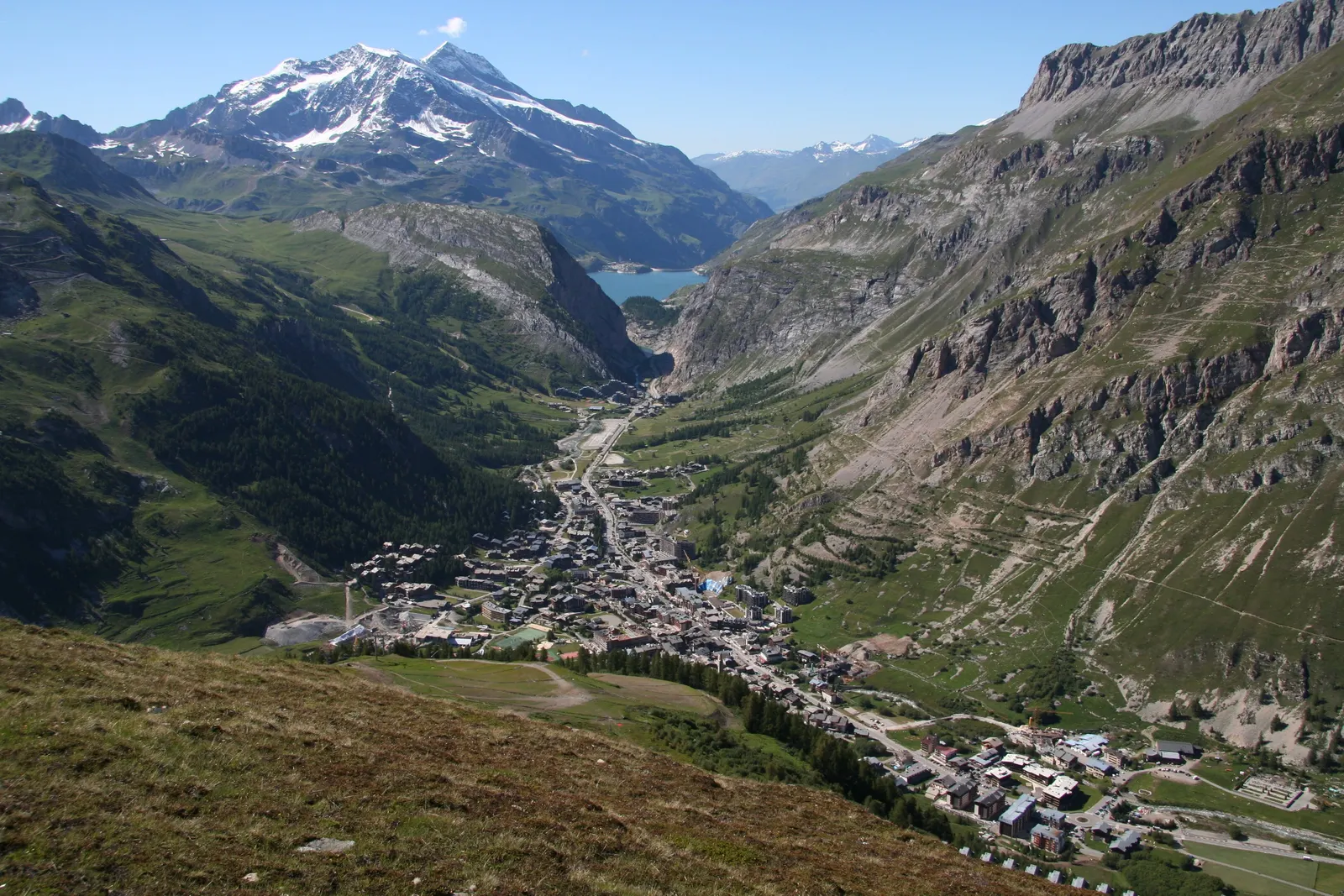 Val-d’Isère seen from the heights in summer, the village centre at the bottom of the Isère valley and the snowy peaks in the distance