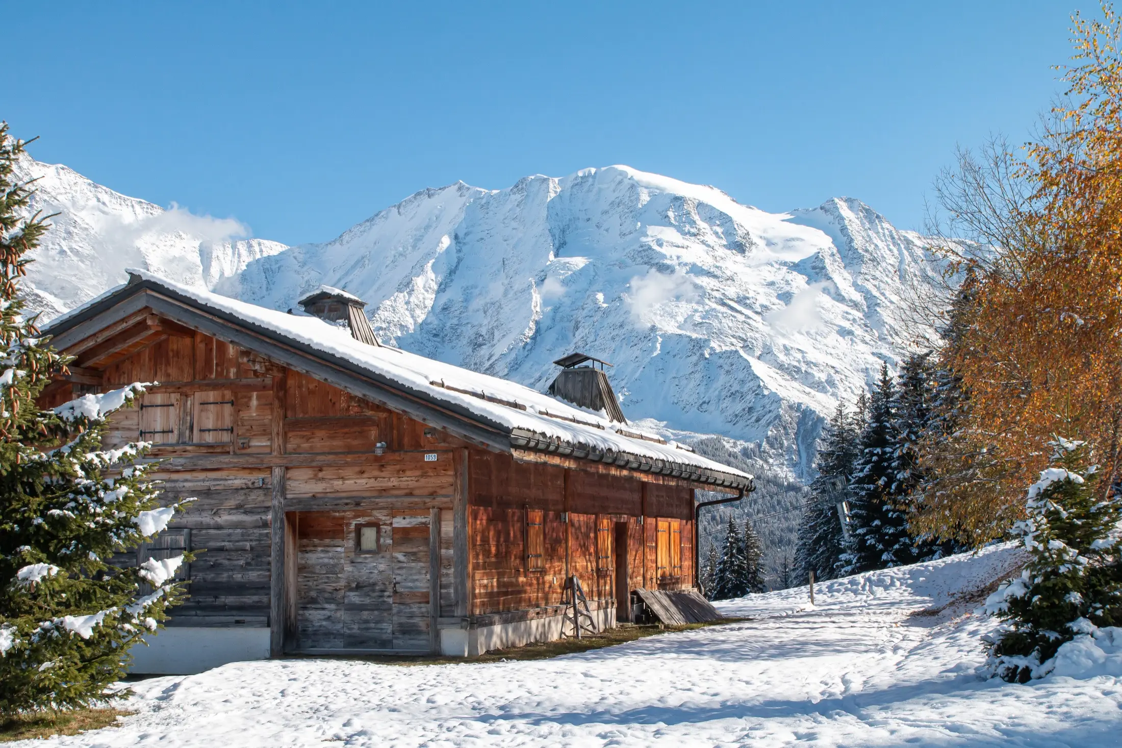 Chalet de montagne sous la neige, au pied des sommets alpins
