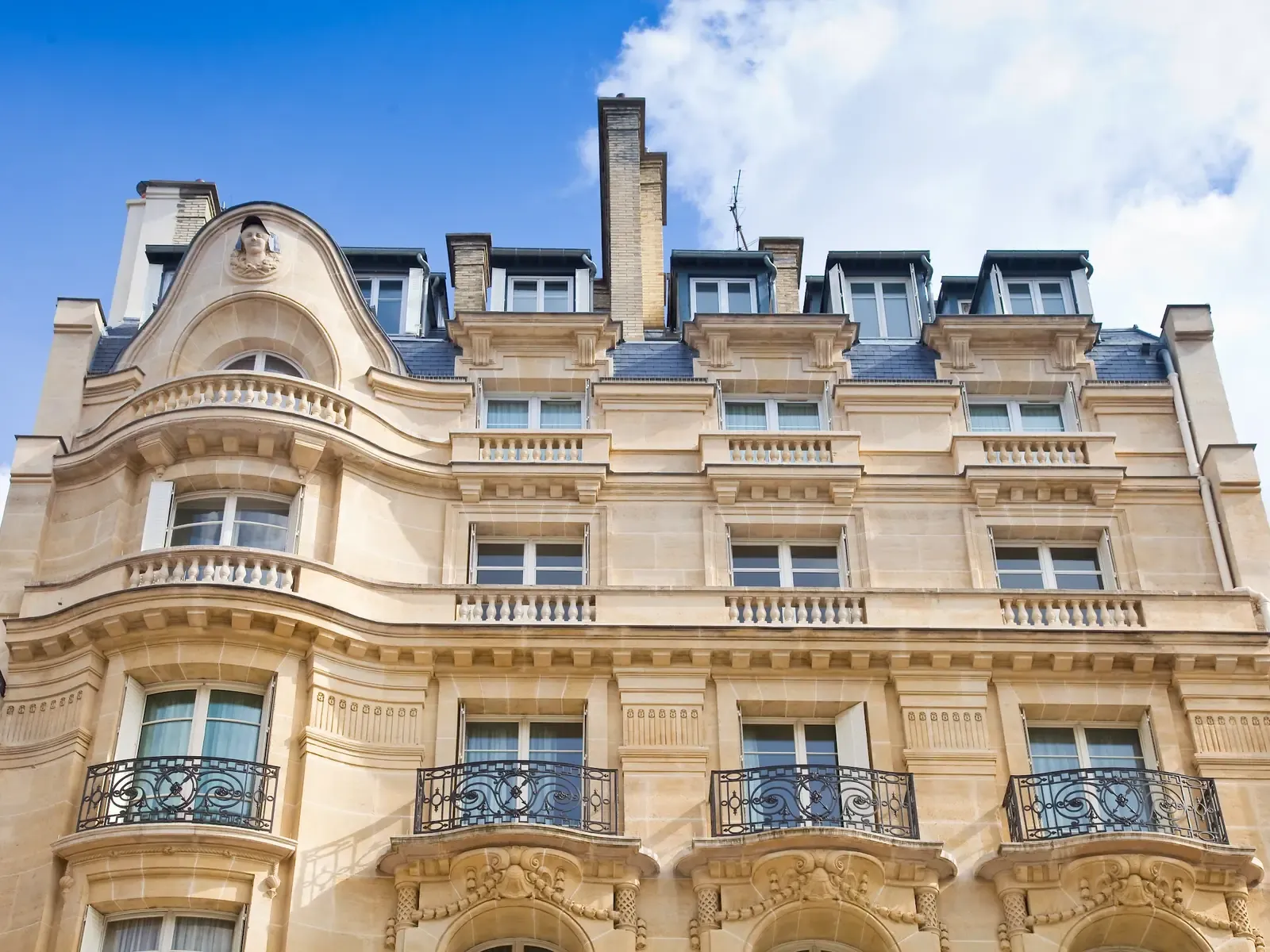 Contre-plongée sur les étages d'un immeuble haussmannien