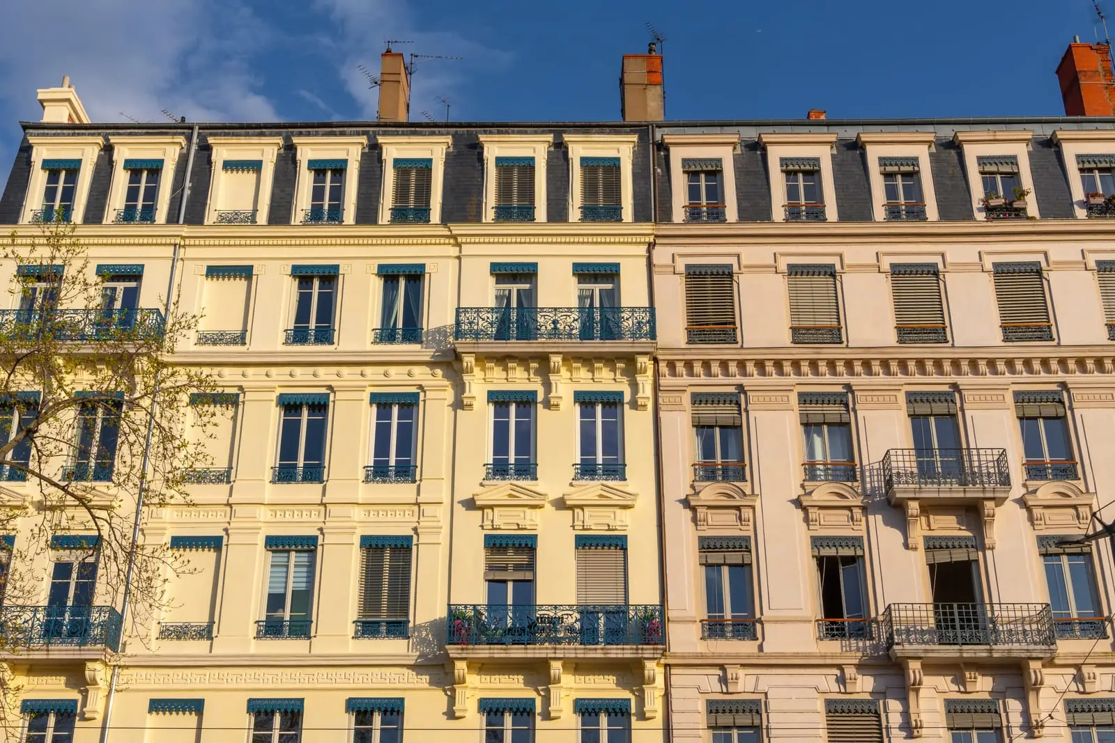 Des façades d’immeubles anciens au soleil, balcons en fer forgé
