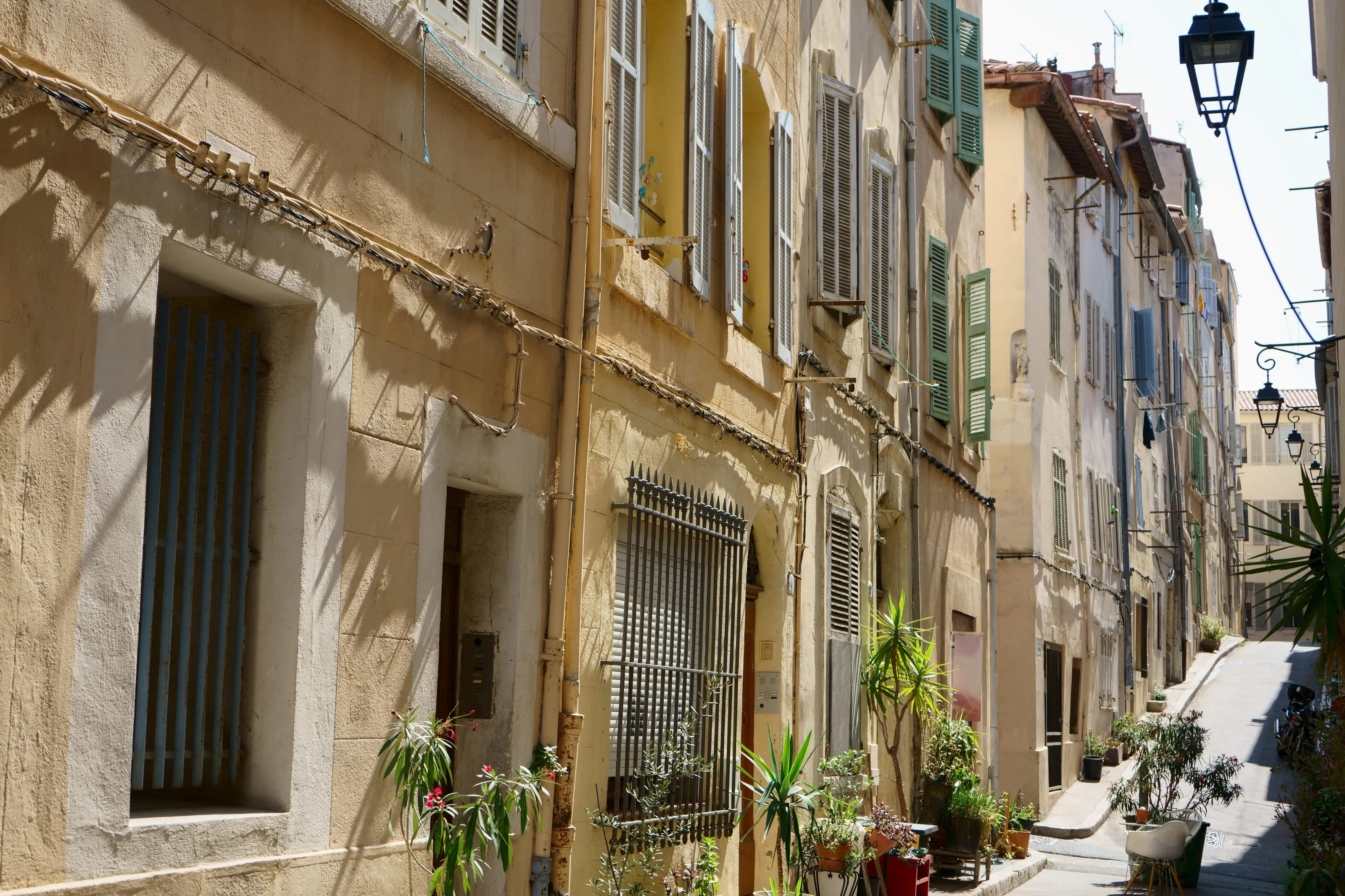 Une rue aux façades pastel et aux volets du Panier à Marseille