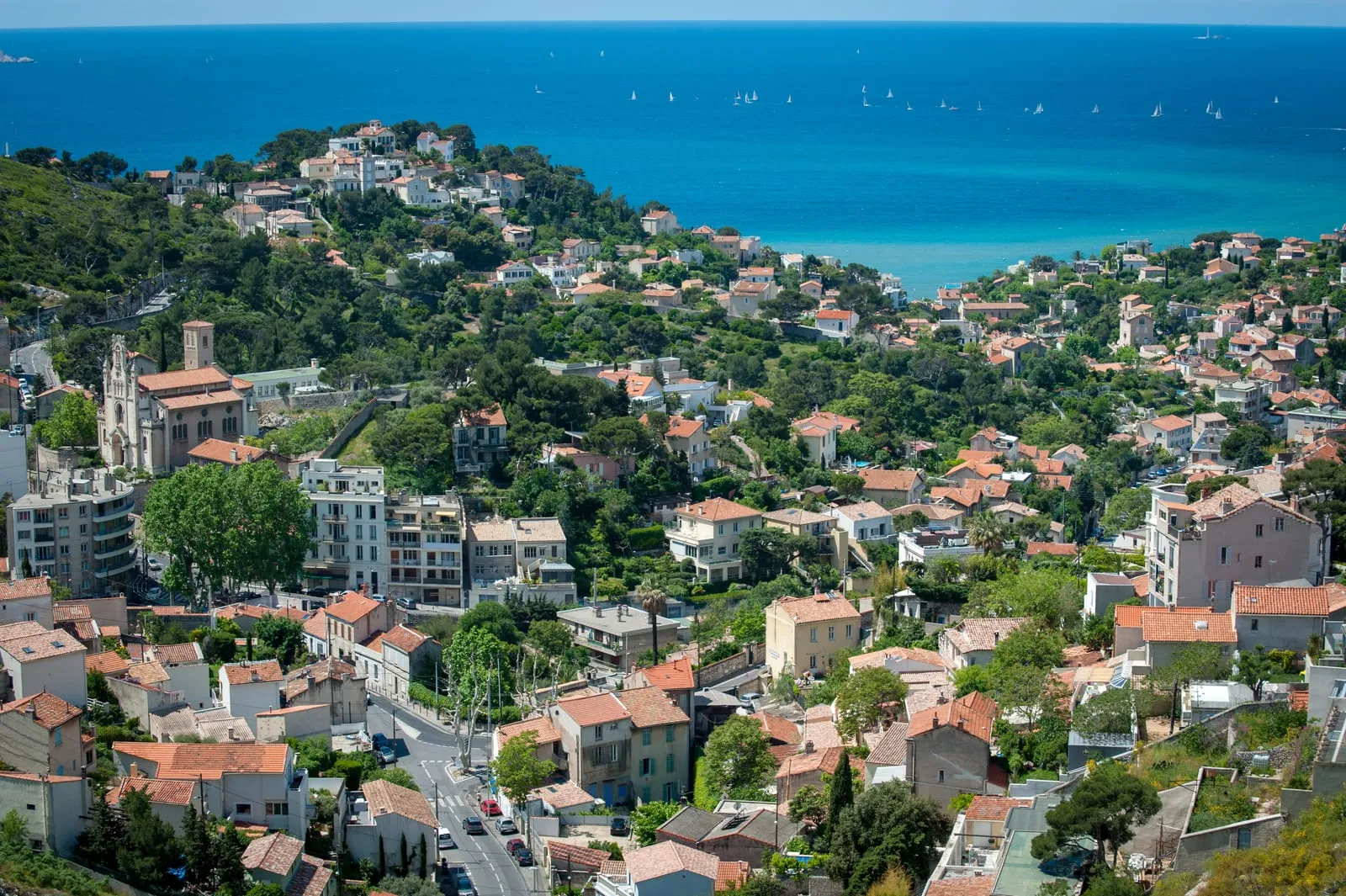Les toits de tuiles et l'église d'un quartier de collines de Marseille