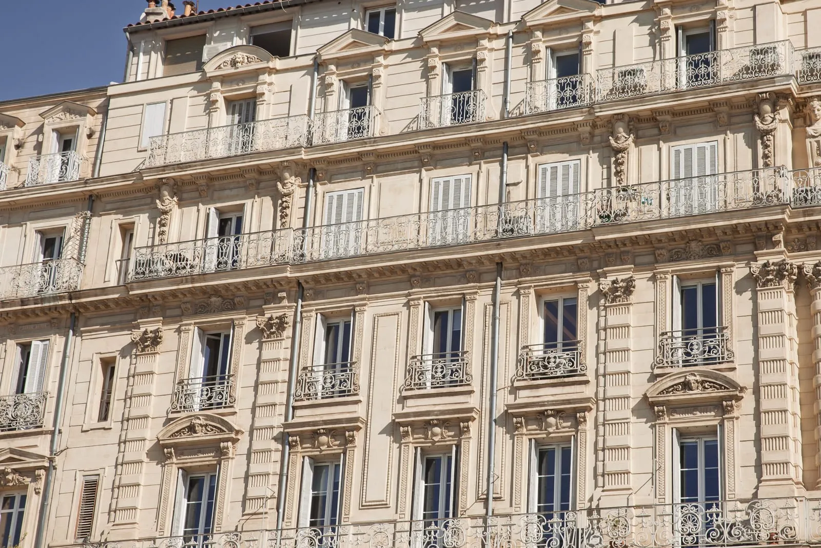 Façade ocre et volets blancs d'un immeuble marseillais