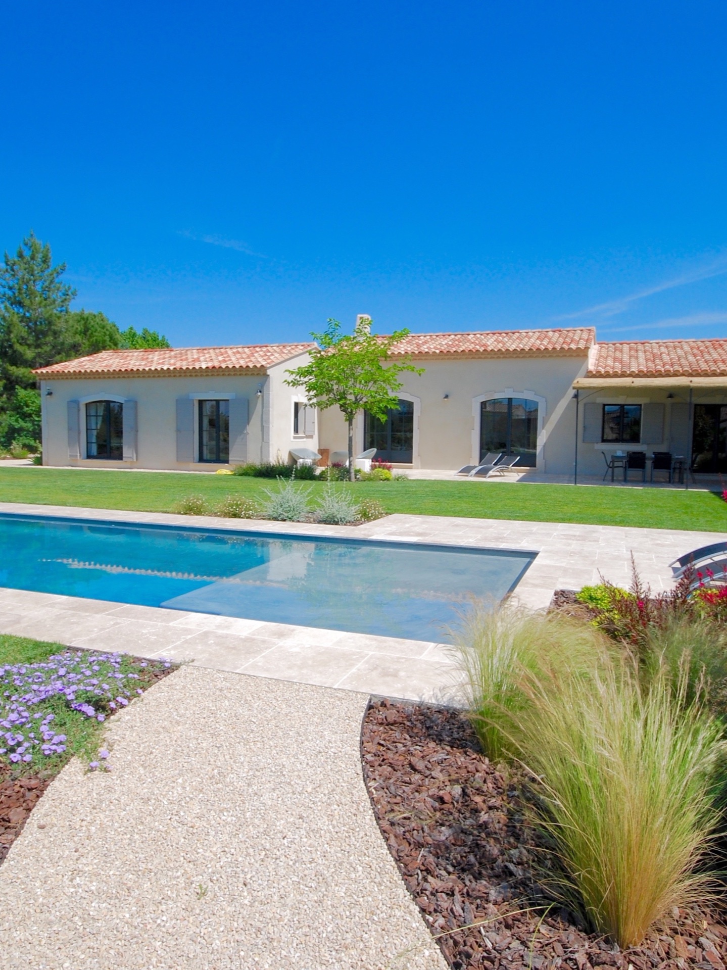 Villa contemporaine au toit de tuiles, piscine et jardins paysagers
